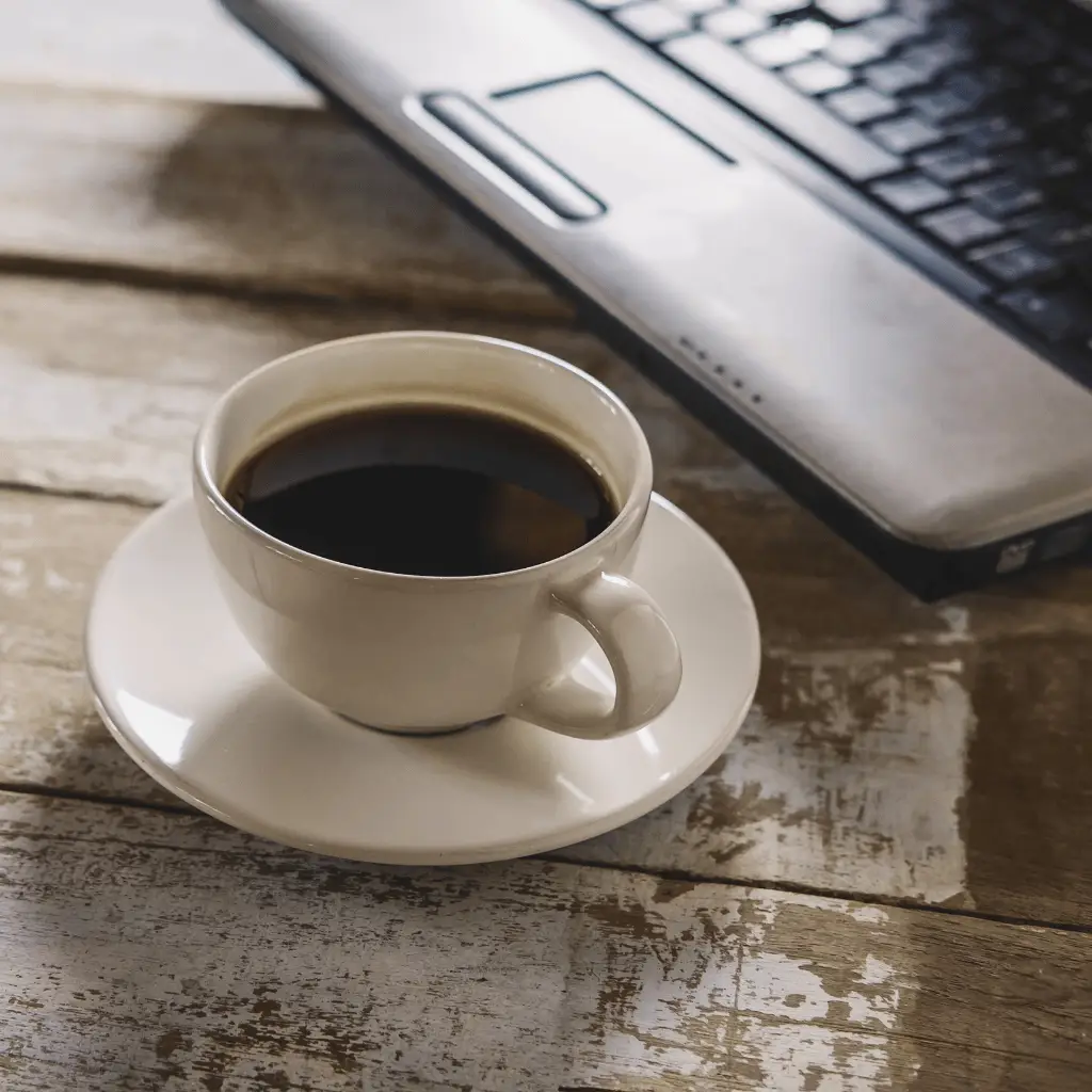 Cup of Coffee Next to Laptop